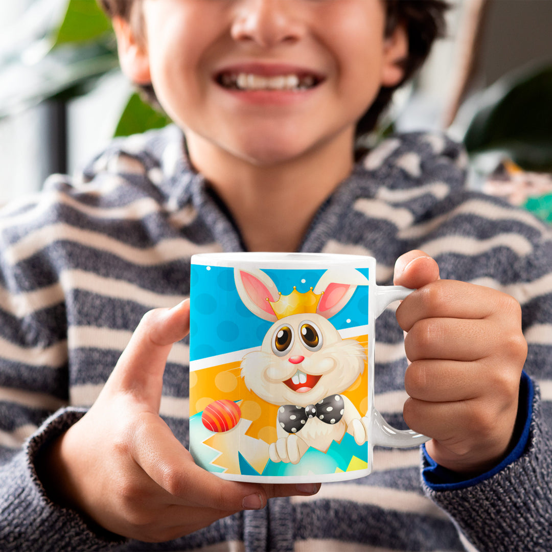 Gutt holder håndlaget påskekopp med fargerikt kanindesign fra Påskemoro gavepose til gutt